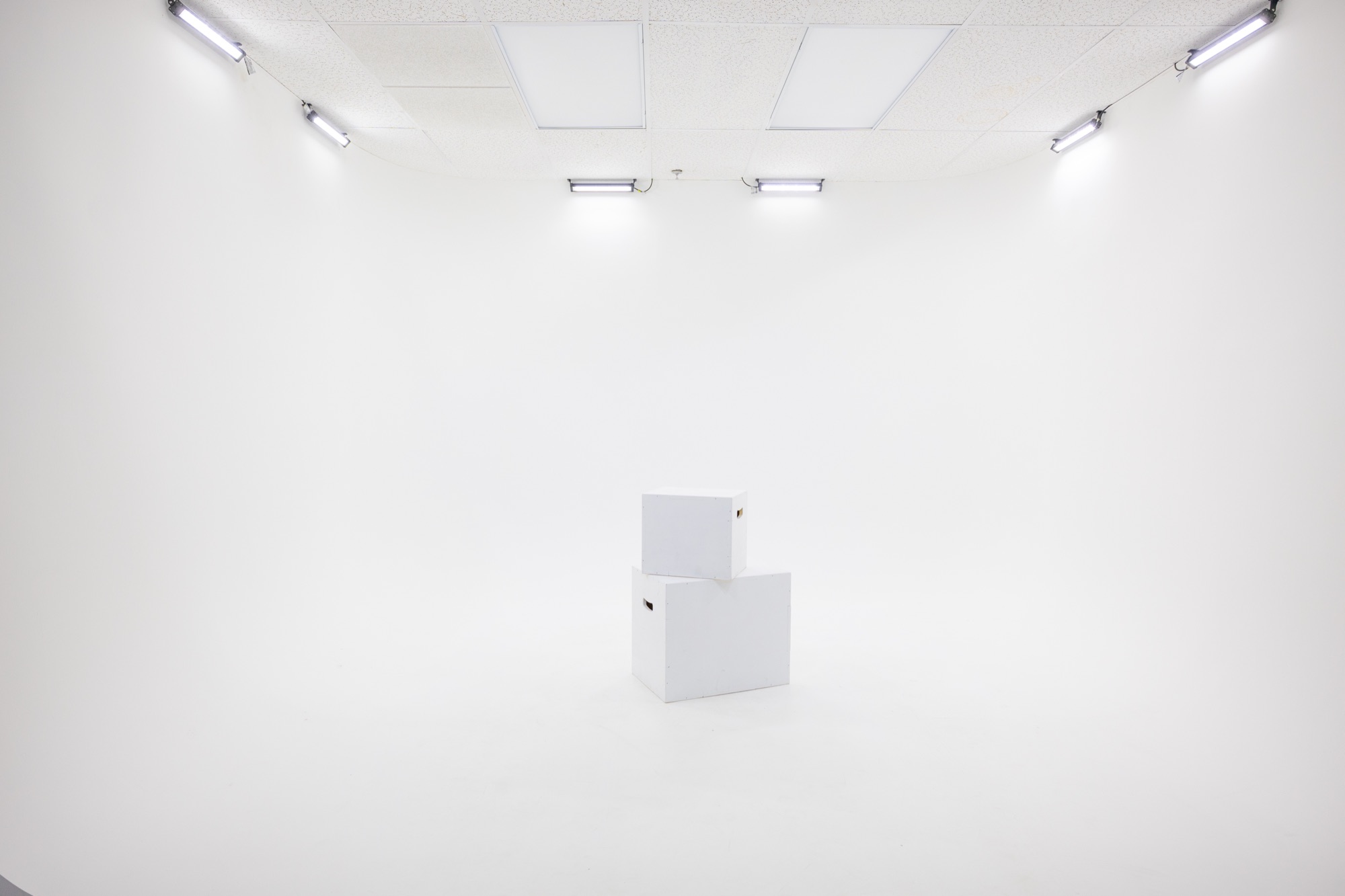 The studio's pre-lit white cyc wall with apple boxes ready for a shoot