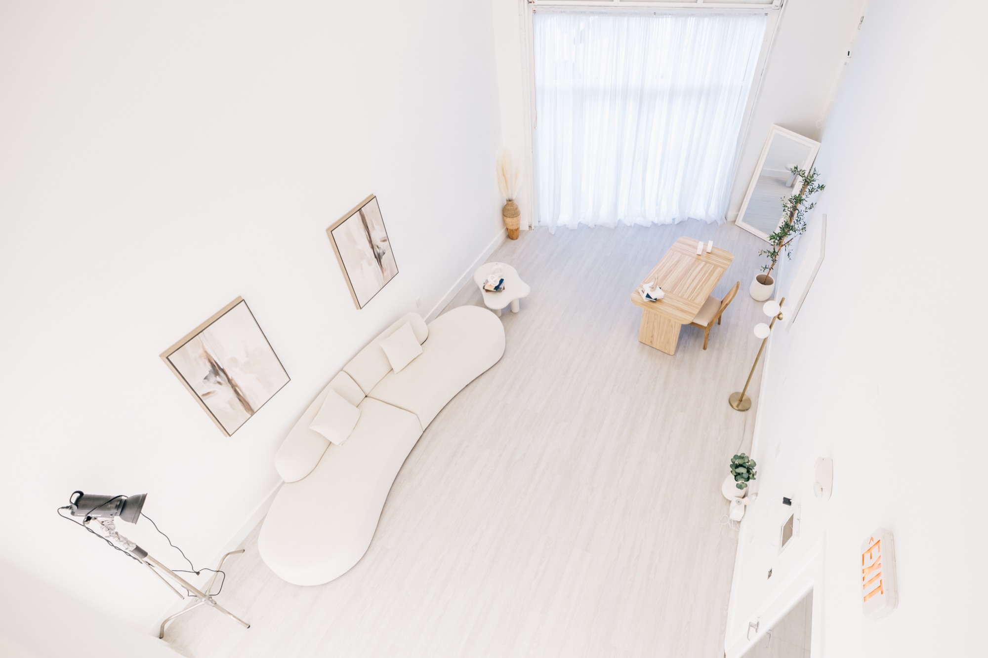 Overhead view of the studio lounge with curved cream sofa and branding desk
