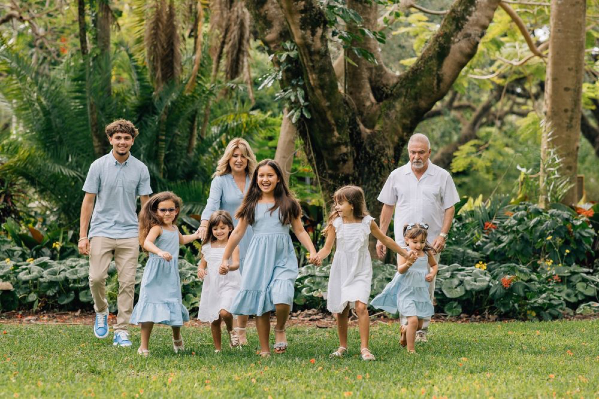 Multi-generational family walking hand in hand through a lush garden