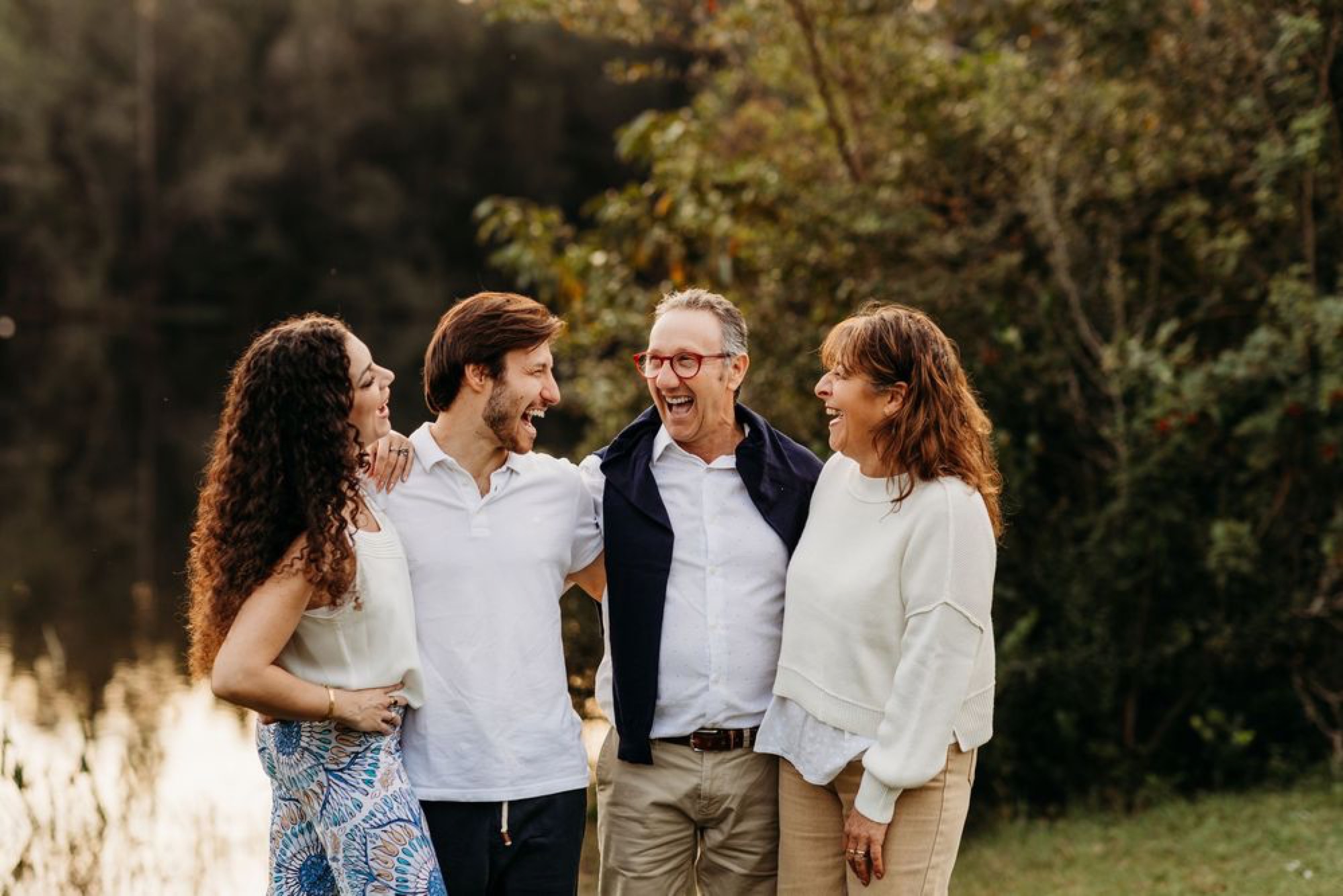 Adult siblings and parents sharing a laugh together at golden hour