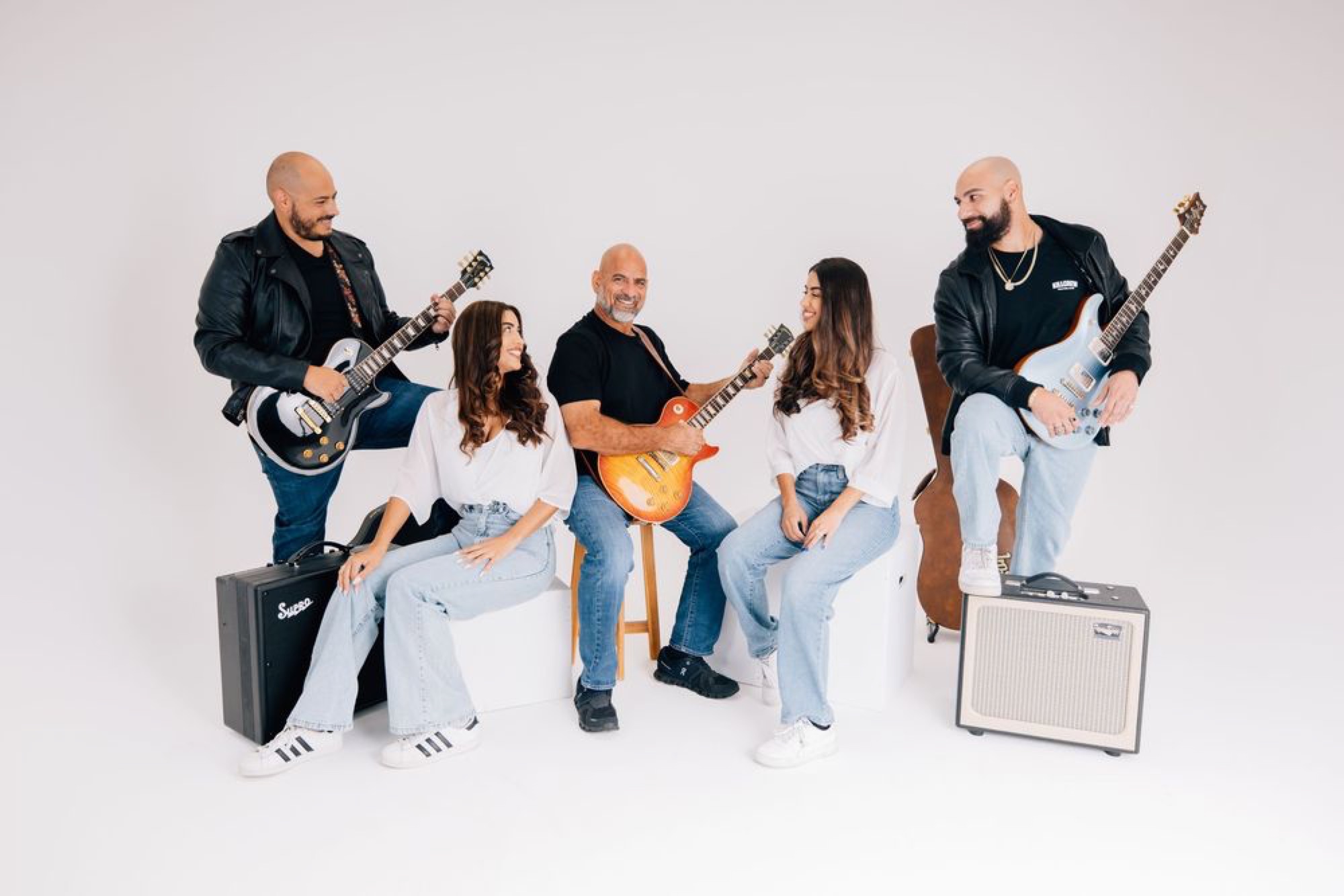 Musical family posing together with their guitars in the studio