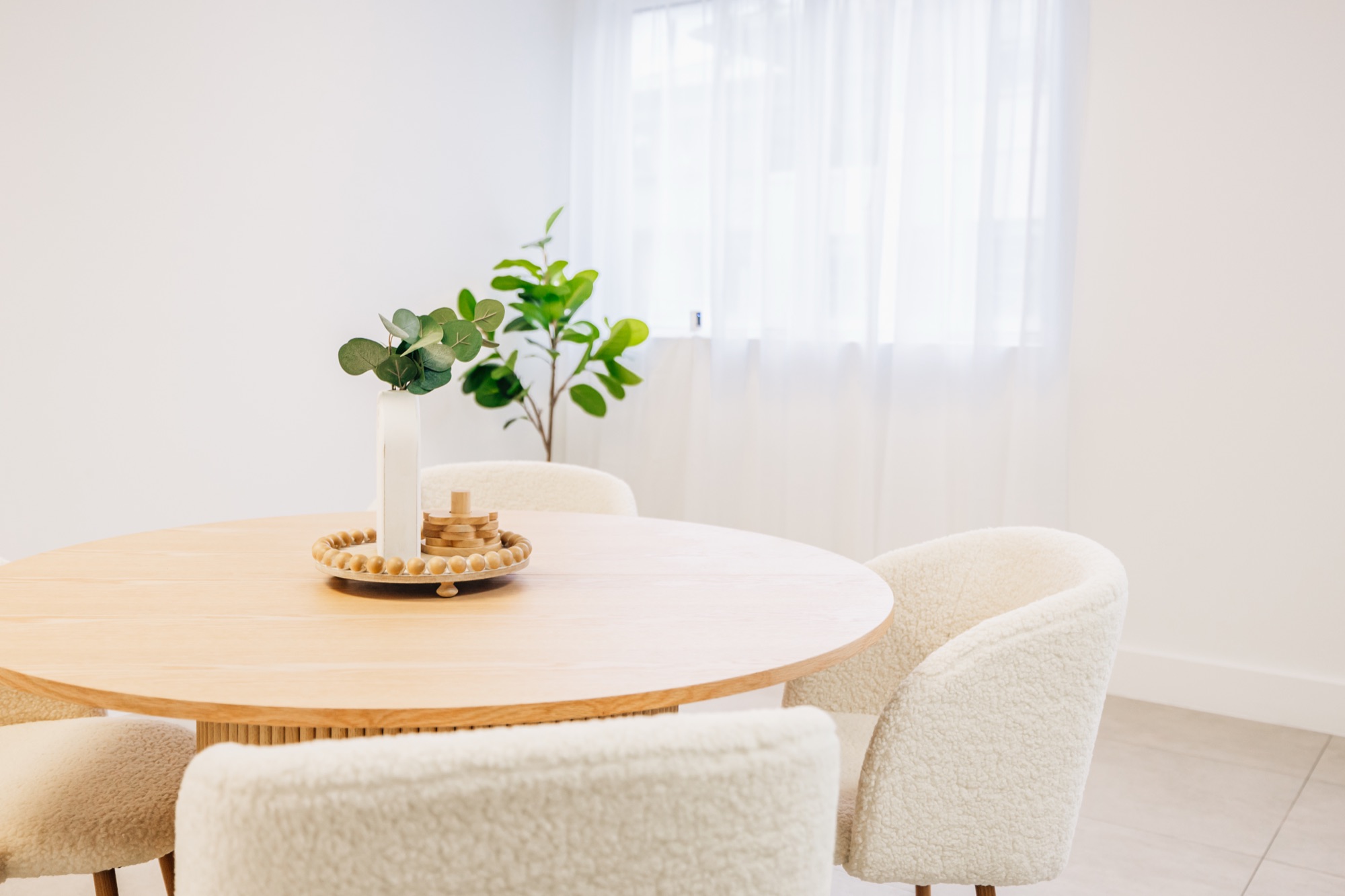 Round wooden meeting table with boucle chairs in the studio client area
