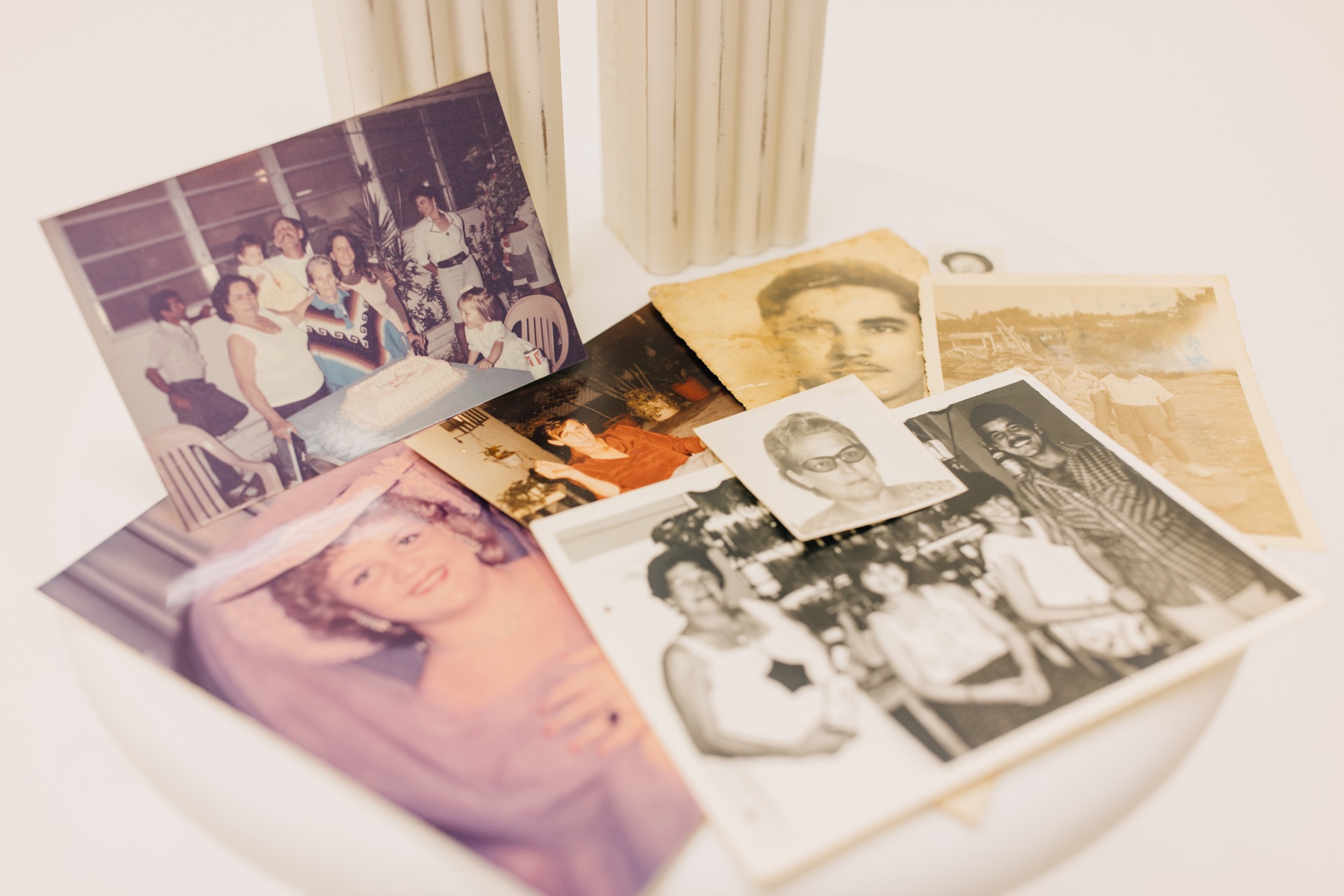 Hands holding a box of old family prints being prepared for scanning